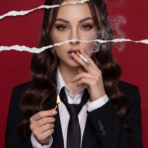 The image is a stylized magazine cover with the word "VOGUE" prominently displayed at the top in bold, black letters set against a deep red background. Below the title, there is a slightly torn effect running horizontally through the image, giving it a la