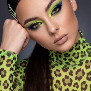 A girl captured in a high-definition professional beauty editorial close-up portrait.

Pose and Body Language: The image is a head-and-shoulders shot. She is leaning her head significantly to the side (viewer's right), resting her temple and cheekbone hea