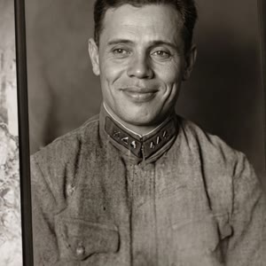 Реалистично анимируй фотографию с естественными движениями человека. Человек мягко улыбается, затем начинает приветливо махать рукой в сторону камеры. Живая мимика, естественное моргание, лёгкие движения головы и тела. Сохрани исходную внешность, одежду, 