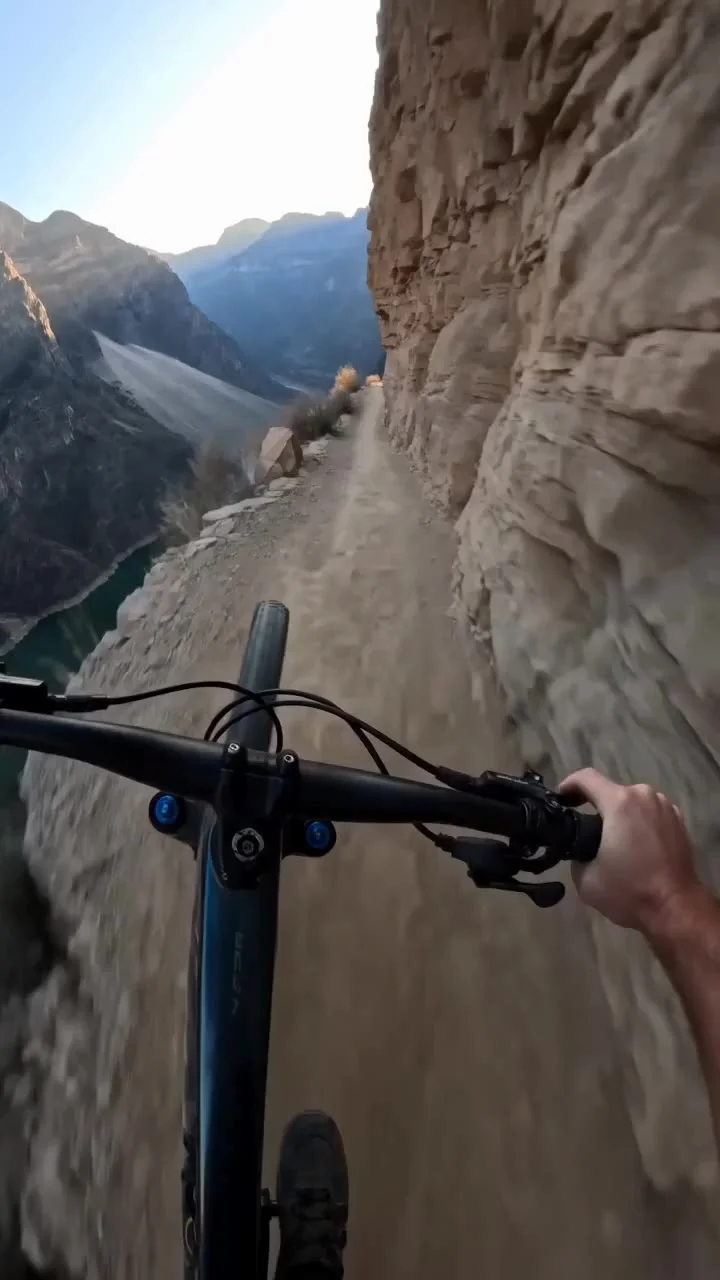 Character
First-person POV of a mountain bike rider, hands gripping the handlebars tightly, subtle body movement reacting to terrain, full focus and tension. Legs pedaling hard, breathing audible.


Scene


POV shot accelerating on a razor-thin dirt path 