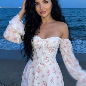 Лицо не менять, 100% сходство с оригиналом.
женщина с очень длинными объёмными волнистыми  волосами стоит на песчаном пляже в сумеречный «blue hour», кадр full‑length / head‑to‑toe, тело чуть развернуто вправо, камера на уровне глаз с небольшым подъёмом д