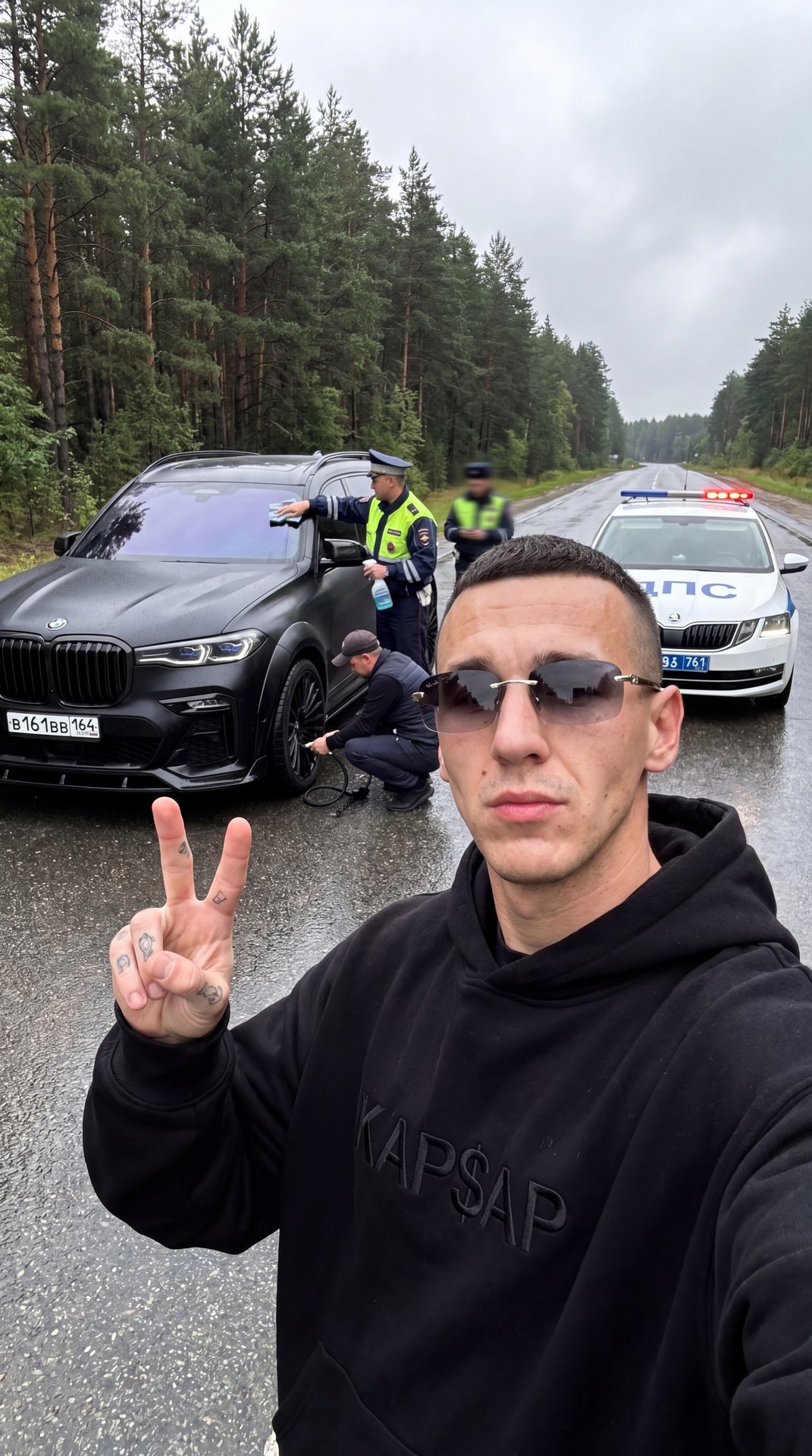 Не меняя внешности парня с фото создай селфи кадр на фронтальную камеру iPhone, 
сцена происходит в пасмурную погоду на мокрой асфальтированной трассе сразу после дождя, небо отличается серостью, влажный воздух,по обе стороны густой хвойный лес и линная п