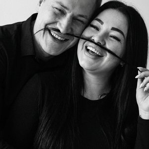 Чёрно-белая фотореалистичная портретная fashion/editorial-съёмка с лёгким кинематографичным оттенком: в кадре двое взрослых, плотно прижатых друг к другу, голова одного слегка позади и выше, второй ближе к камере; оба запрокинули головы назад и немного в 