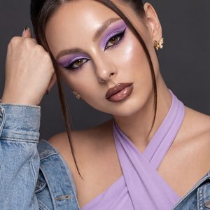 A girl captured in a high-end, glamorous beauty editorial portrait shot with professional studio lighting.

Pose and Body Language: The image is a close-up framing the head and shoulders. Her head is tilted significantly to the left (viewer's left), resti
