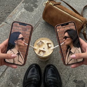 Фотореалистичная уличная lifestyle/fashion\-фотография в стиле editorial, вертикальный кадр 9:16 съемка сверху от первого лица \(POV\) сидящего человека; внизу кадра видны колени и голени, ноги вытянуты вперед на бетонной поверхности у бордюра/ступени, ка