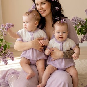 Ultra-realistic professional photo of a young mother with her two identical twin baby girls, 8 months old. They are sitting together on a soft cream linen rug. Mother weighs 65 kg, has a slim but naturally soft body type — not skinny, healthy and feminine