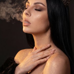 A girl captured in a dramatic, cinematic side-profile portrait shot on a professional camera. Specifically, she is turned in a three-quarter profile facing left, with her head tilted slightly upward and back. Her eyes are completely closed in a look of de