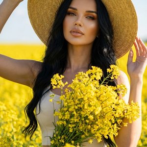 Фотореалистичная fashion-съёмка в поле жёлтых цветов (рапсовое поле), девушка стоит среди цветов, кадр по пояс, корпус слегка повернут, одной рукой придерживает широкополую соломенную шляпу, вторая рука поднята, уверенная элегантная поза и взгляд в камеру