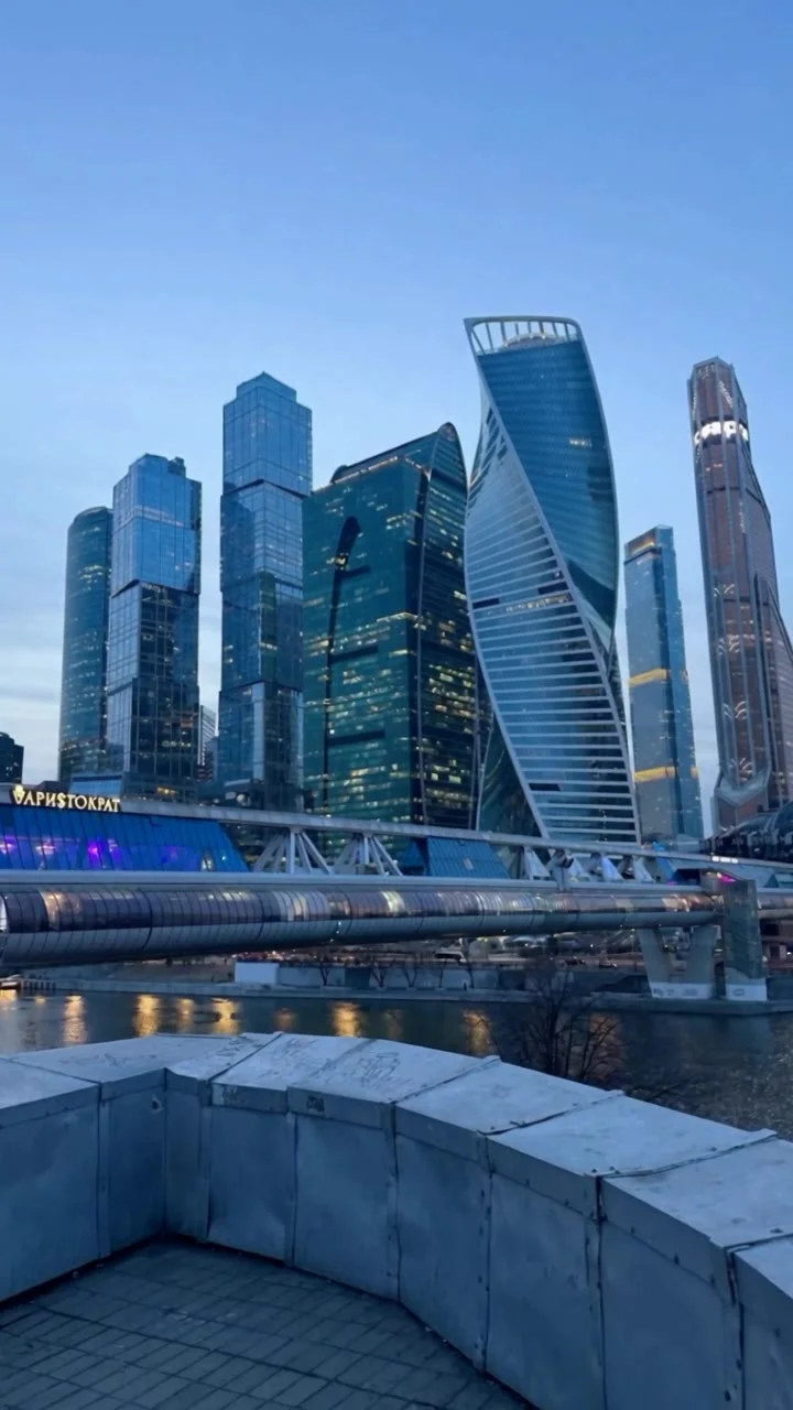 Use the two uploaded images as follows:
@image_1 is the exterior location reference. It defines the place, building, skyline, architecture, atmosphere, and the destination the camera must approach from outside.
@image_2  is the main subject and interior i