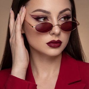 A girl is captured in a professional, stylized photo shoot presenting a confident and slightly playful demeanor. She is posed with her head turned slightly to her right (viewer’s left), her gaze directed off to the side with eyes looking to the right as w