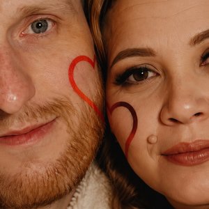 Фотореалистичный кинематографичный extreme close-up портрет, съёмка на уровне глаз.
В кадре лица мужчина и женщина крупным планом — видна половина лица мужчины и женщины их щёки нежно прижаты друг к другу, передавая глубокую нежность и любовь.
На каждой щ