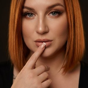 Ультрареалистичный 8K портрет по грудь, фото снято профессиональным фотографом. Identity lock: лицо на 100% идентично исходному референсу — полностью узнаваемо, без искажений и без изменения пропорций, черт и внешности; легкая ретушь. Девушка слегка повер