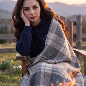 Hyper-realistic authentic raw photograph, completely indistinguishable from reality, unretouched lifestyle capture, zero CGI look. Beautiful spring sunset at a mountain cabin yard; warm campfire with glowing embers in the soft-focus foreground; subject se