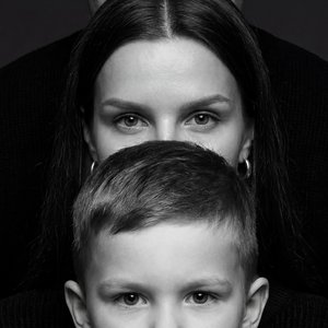 Создай крупный портрет, не меняя черты лица, перенеси в точности с прикрепленной фотографии. Черно-белый, выразительный студийный портрет крупным планом. Крупный план сфокусирован на лицах мужчины, женщины и ребенка . В самом конце стоит мужчина, видно то
