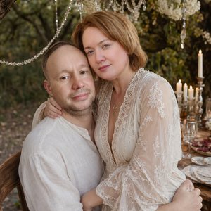 Close medium shot from a slightly elevated high angle, very intimate bohemian wedding portrait.

Strictly preserve the EXACT faces from the reference image — 100% identical features, skin texture, hair, expressions and proportions. Do not modify faces.

T