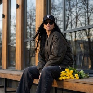 3. Используй лицо и внешность человека с загруженного входящего фото, сохрани 100% сходство, естественные пропорции и индивидуальные черты без изменений. Создай фотореалистичный вертикальный портрет в той же одежде: черная бейсболка с белым логотипом NY, 