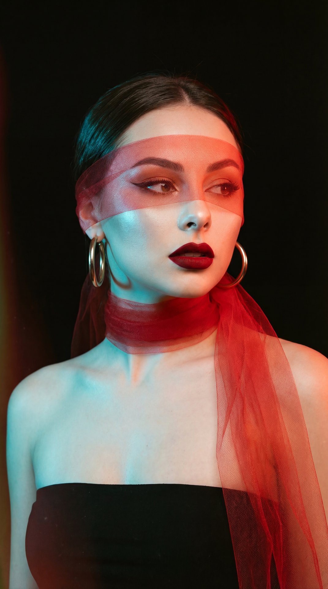 A girl, medium close-up head-and-shoulders portrait, eye-level camera angle, professional DSLR studio photography. Slender figure. Standing with torso angled slightly forward-left, completely turning her head to gaze sharply off-camera to the right. Arms 