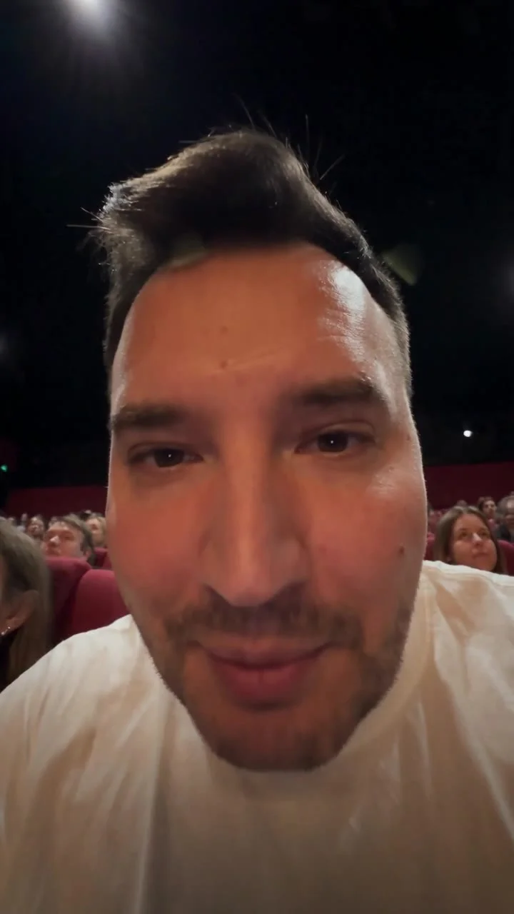 Vertical smartphone video, shot on iPhone 15 Pro, 4K HDR, 60fps, realistic handheld shake, natural low-light sensor noise, authentic UGC found-footage style. Filmed inside a massive IMAX 70mm auditorium at night: enormous wall-to-wall IMAX screen @image_4