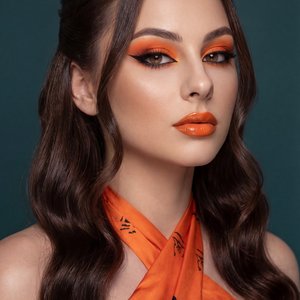 A girl is captured in a close-up portrait shot, facing slightly to the right with her head turned toward the camera. Her shoulders are visible, and her pose is relaxed yet poised, emphasizing her confident expression. Both hands are not visible in the fra