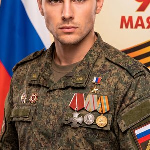 Мужчина в военной форме с медалями на груди, уверенно смотрит в камеру. Его лицо выражает решимость и гордость за службу. На заднем плане - флаг и символика Победы. Атмосфера патриотизма
*Точно передать мои черты лица и внешность