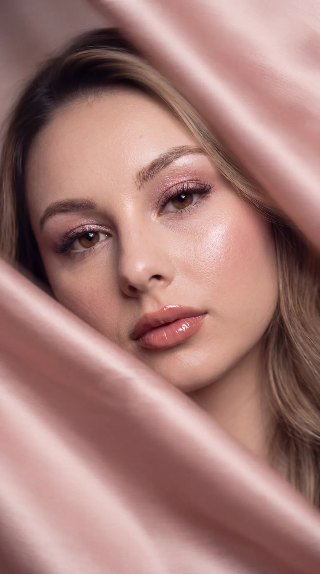 Create image: use the attached image as the main facial reference while preserving recognizable identity essence, facial proportions, and natural asymmetry.


An intentional motion-blur luxury beauty portrait wrapped in soft blush-pink satin fabric. The s