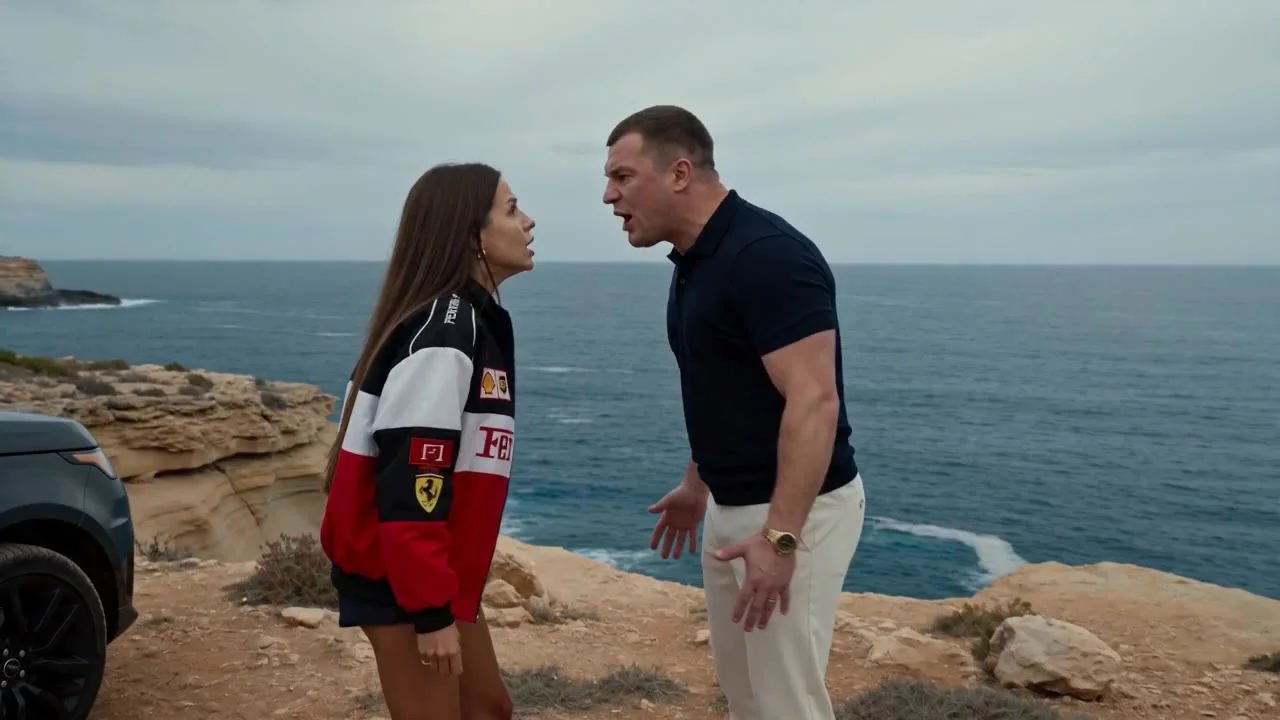 Scene structure:
0s–2s: A man(@image2) and a woman(@image1) are having a furious argument on a cliff above the ocean next to a black car. They stand facing each other at close range, yelling loudly, their faces full of anger, gestures sharp and aggressive